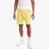 Man wearing yellow Levis Mens Sweat Shorts with a white tank top and white sneakers, standing on a white background.