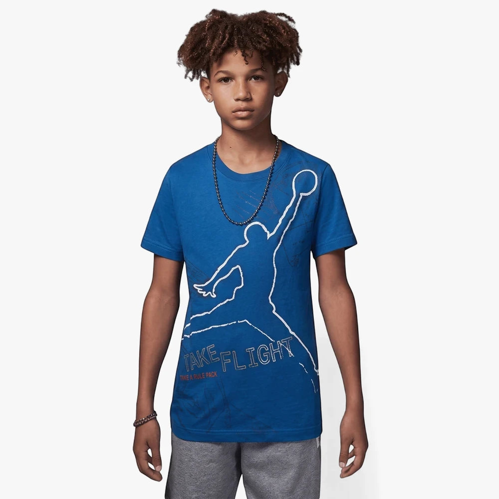 Young boy wearing a Nike Jm Flight Stamp short sleeve tee in industrial blue with a white Jumpman logo.