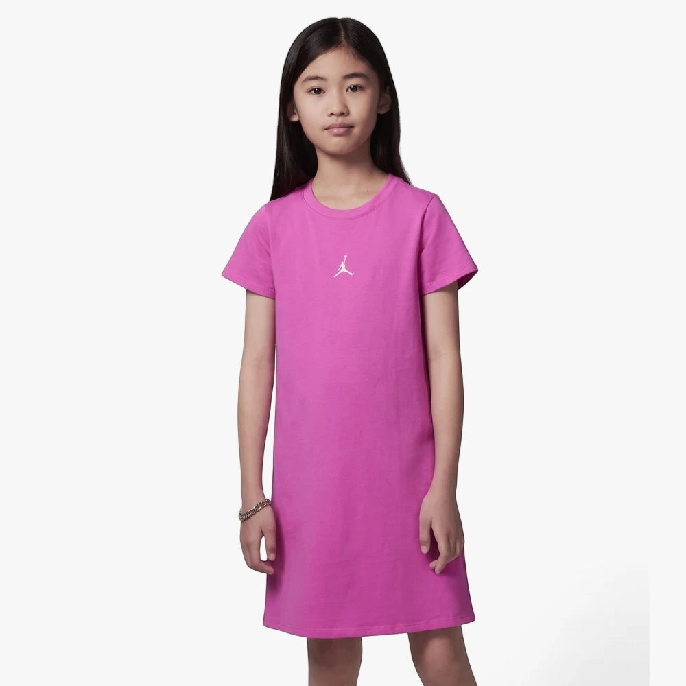 Young girl wearing a vibrant fire pink Nike Jordan T-shirt dress with a white Jumpman logo, posed front-facing.