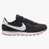 Nike Girls Md Valiant Sneaker in black with white swoosh, white midsole, and red outsole, shown from a side profile view.