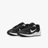 A pair of black and white Nike Girls Revolution 7 running sneakers, featuring a white swoosh and white soles, side view.