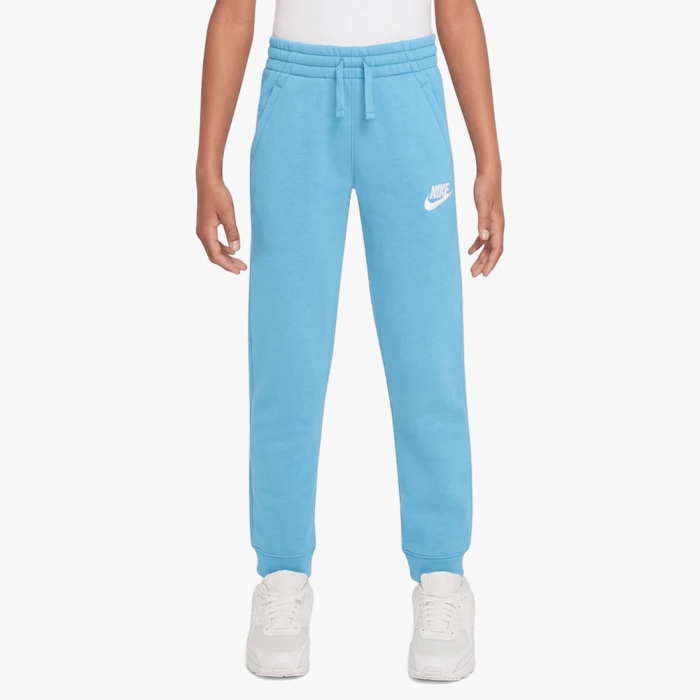 Light blue Nike Kids Club Fleece Jogger pants for children, featuring a white Nike swoosh logo, shown being worn.