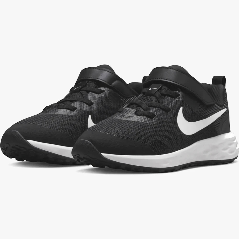 Black Nike Kids Revolution 6 sneakers with white swoosh logos and white soles, viewed from an angled perspective.