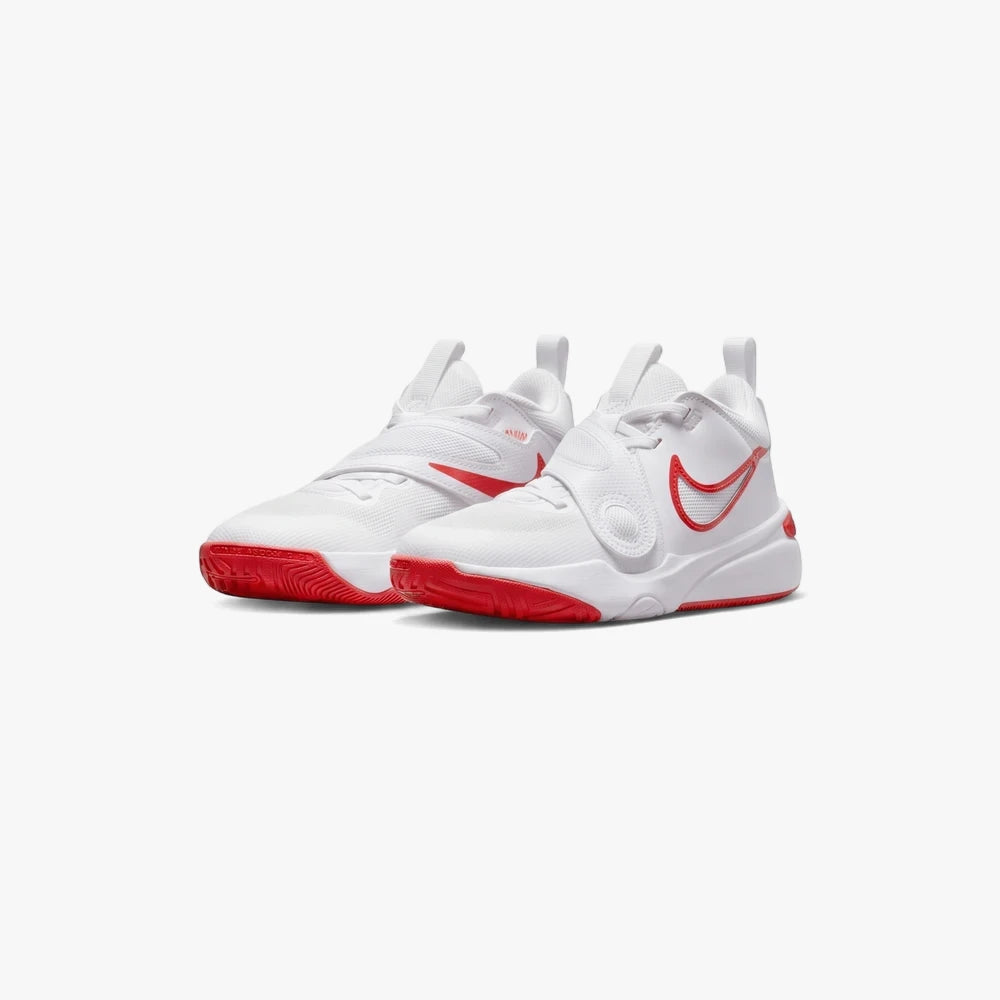Pair of Nike Kids Team Hustle Mid sneakers in white with vibrant red outsoles and swoosh accents, viewed from a slight angle.