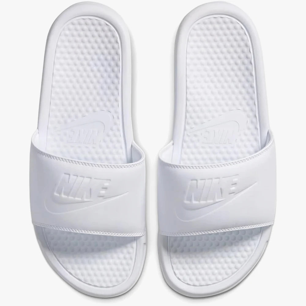 A top-down view of white Nike Womens Benassi Jdi slide sandals, featuring embossed Nike logos on the strap and footbed.