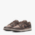 A pair of Nike Womens Dunk Low sneakers in ironstone and anthracite brown, presented in a side view on a white background.