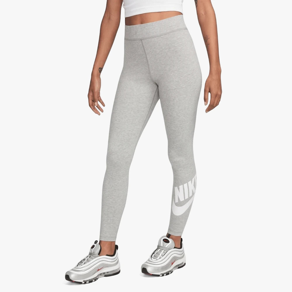 A woman models gray Nike High Rise Tights featuring a white Nike logo on the leg, paired with silver Nike Air Max 97