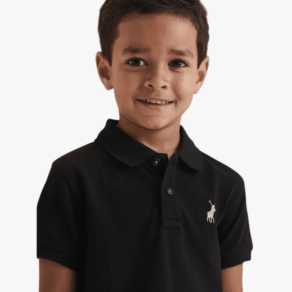 Young boy wearing a black short-sleeve Polo Austin golfer shirt with a white embroidered logo, front view.