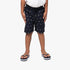 Polo Boys Bradley Monogram Beach Shorts in navy with a repeating monogram pattern, worn with striped flip-flops.