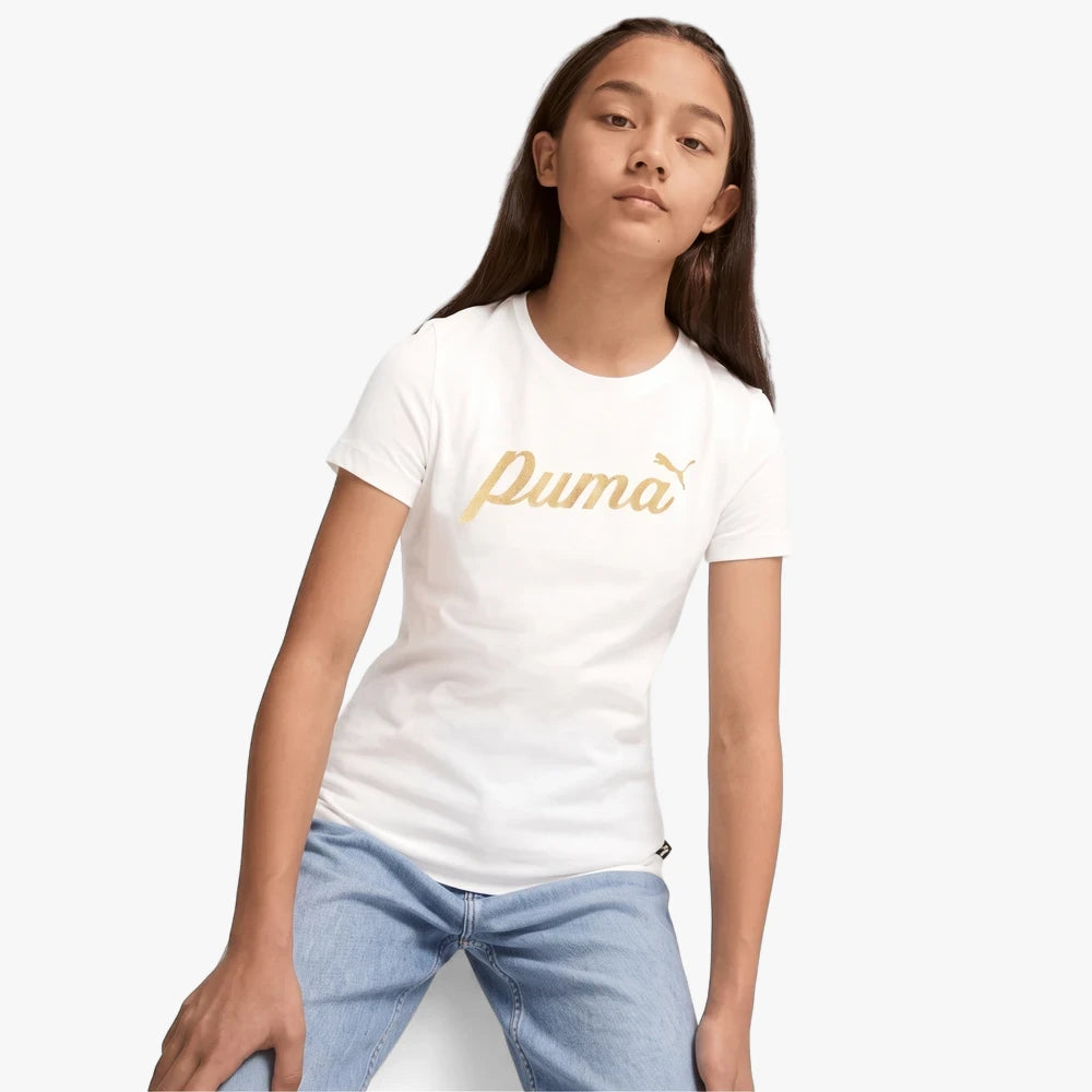 Young girl wearing a white Puma Ess+ Script short sleeve tee with a gold logo and light wash blue jeans.