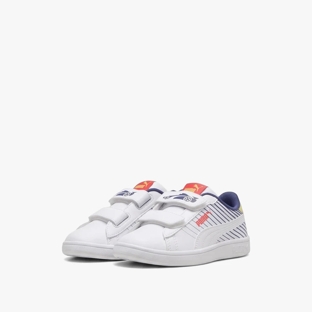 White Puma Kids Smash 3.0 sneakers with three velcro straps, blue stripes, and a red logo, shown from a low angle.