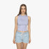 Woman wearing a lilac Ripcurl Womens Search Classic Rib Tank Top and light blue denim shorts, standing on a white background.