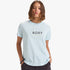 Light blue Roxy Womens Ocean Road Ii Tee Cooling Spray worn by a model with hands in pockets, featuring a circular Roxy logo.