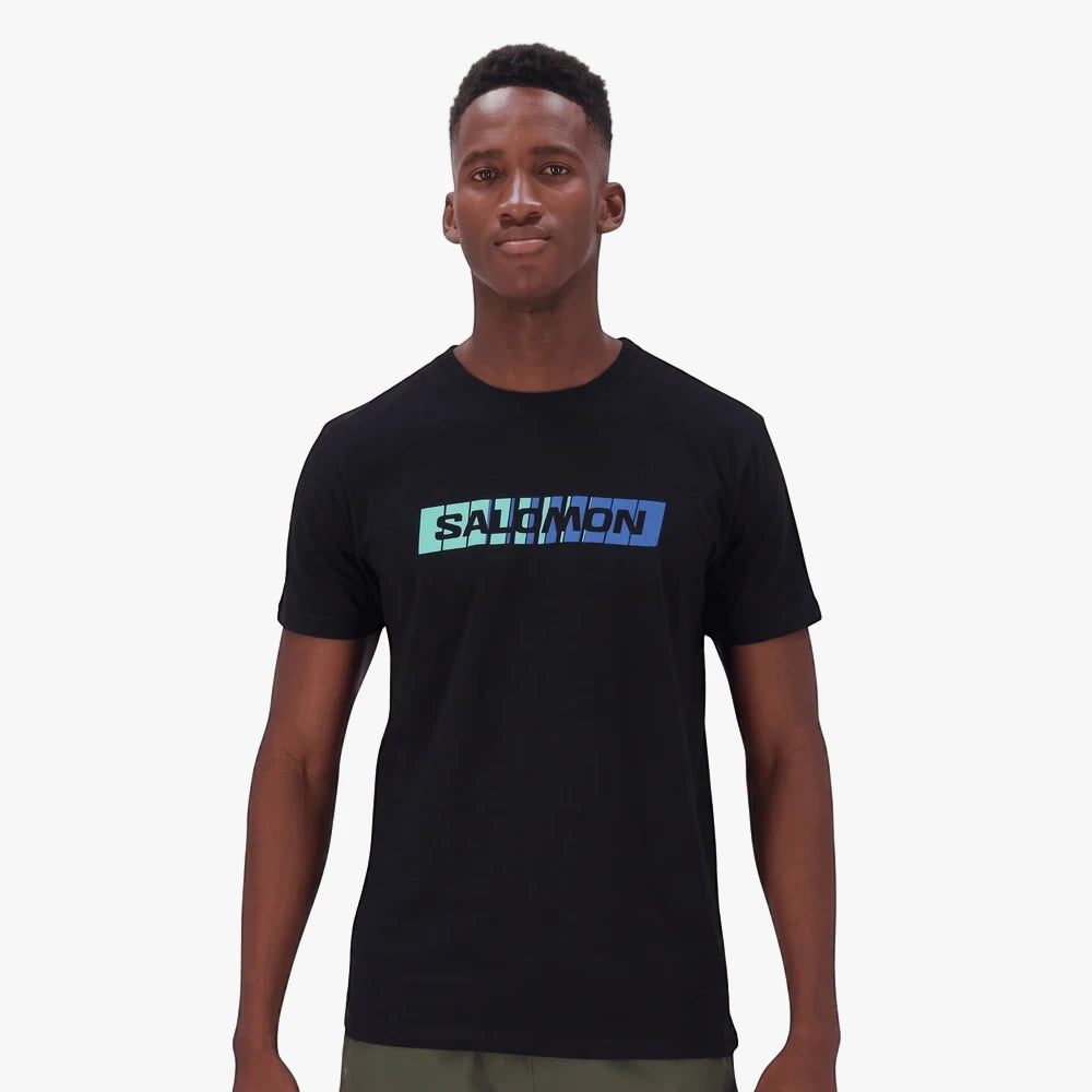 Black Salomon Mens Bold Short Sleeve Tee worn by a male model, featuring a distinctive blue and teal gradient logo across