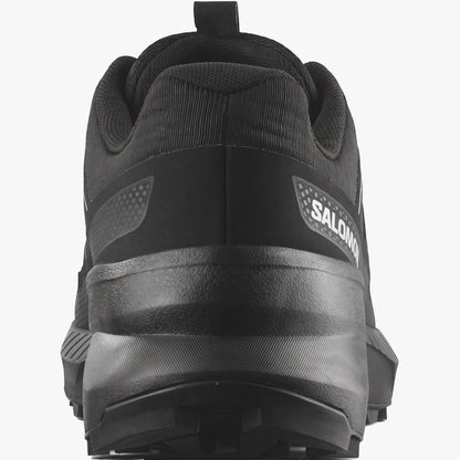 Rear view of a black Salomon Mens Speedcross Peak Trail Sneaker, highlighting the white logo and rugged sole.
