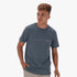 A male model wears a dark blue Salomon Vision II short sleeve tee with an embossed chest logo, looking to the right in a