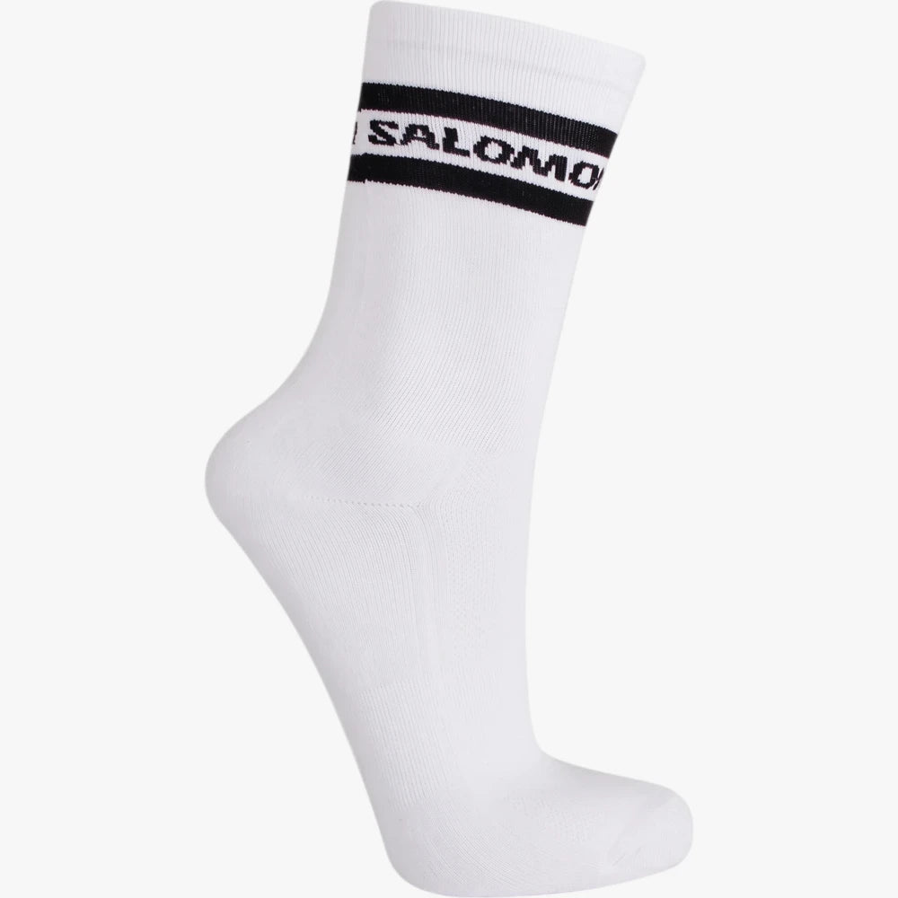 White Salomon Sporty Crew Sock featuring black stripes and a logo on the ribbed cuff, viewed from a side angle.