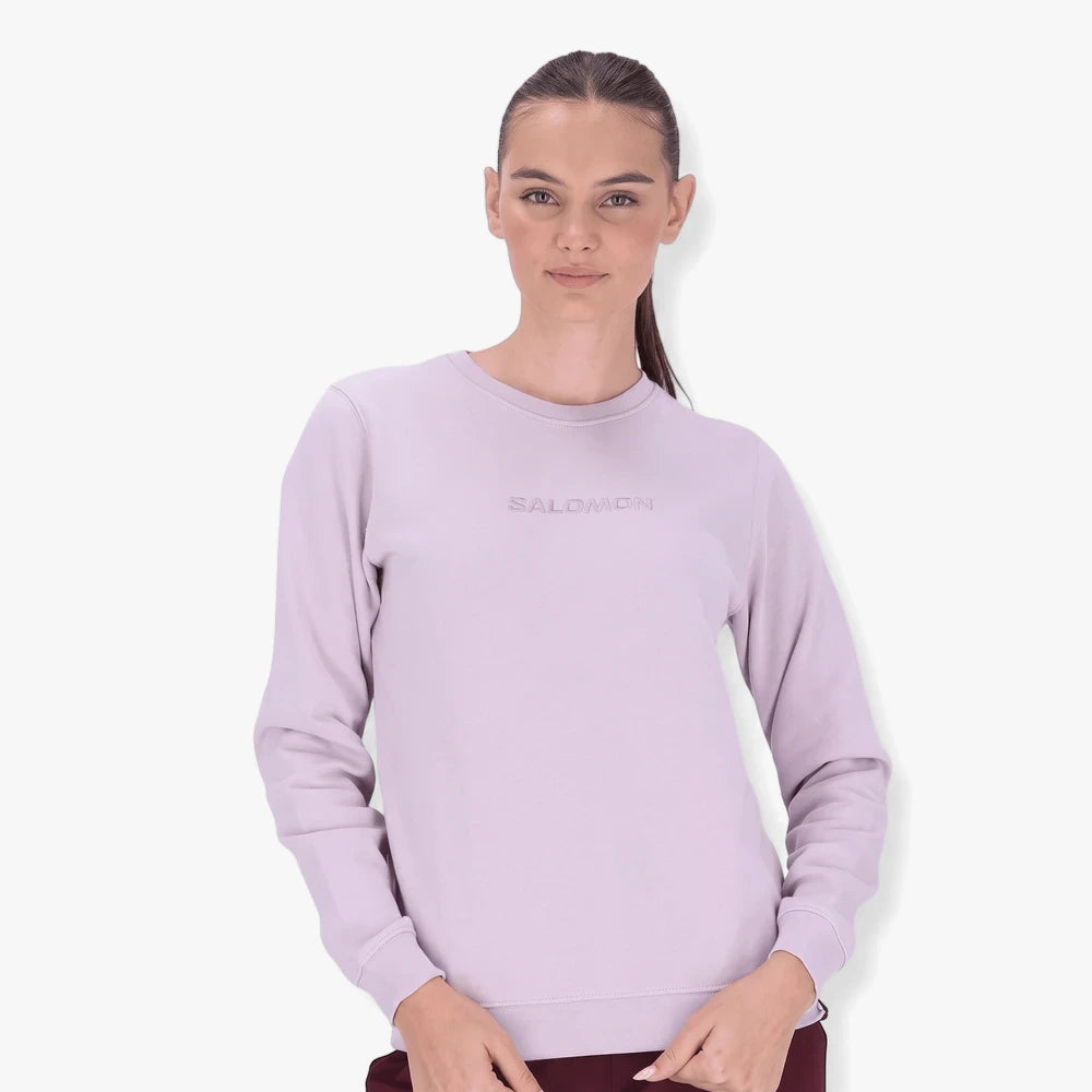 Salomon Womens Core Crew Fleece Sweater in galactic lilac, worn by a female model in a waist-up shot.