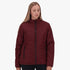Woman models a Salomon Womens Cove Jacket in cherry liqueur, a maroon puffer jacket with black zippers.