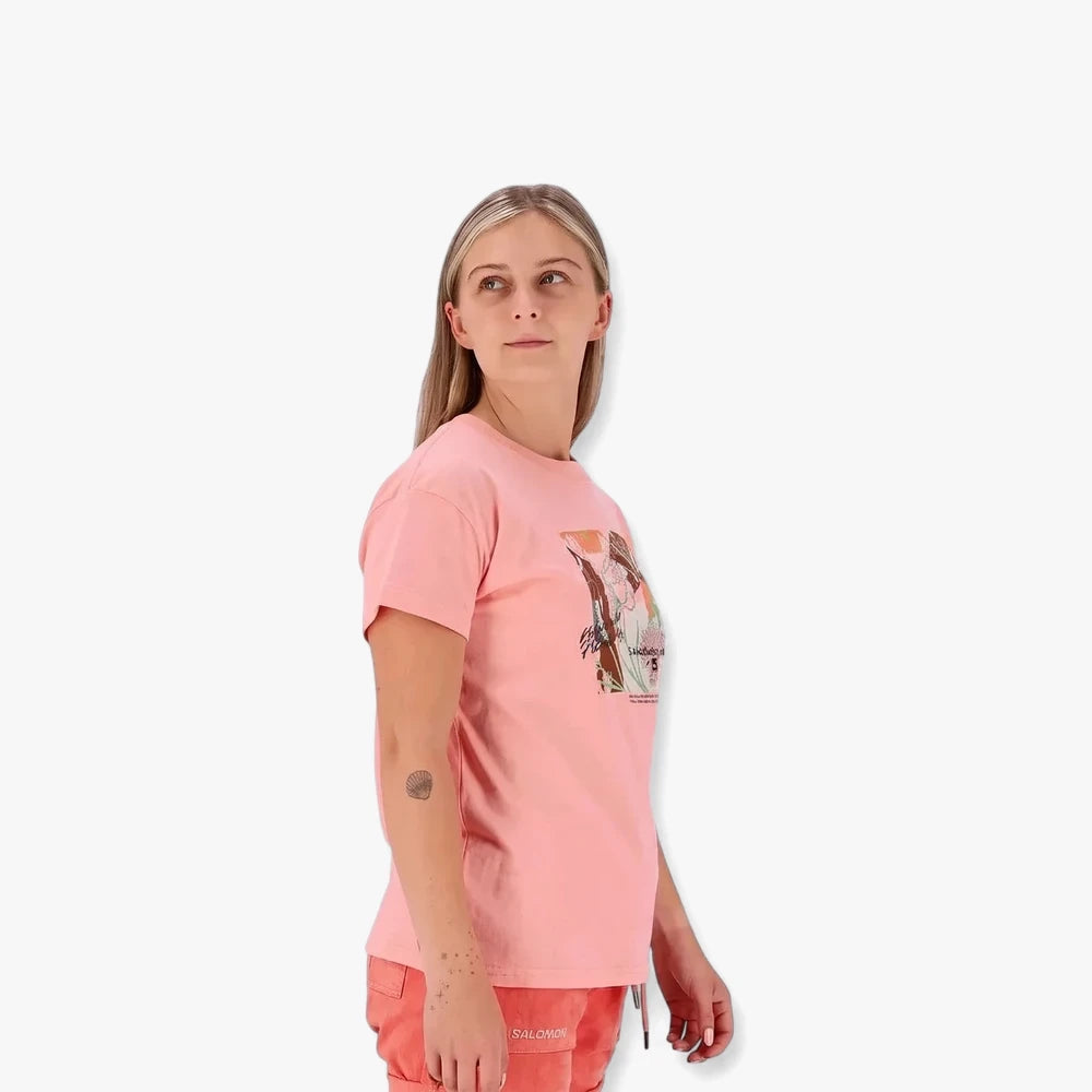 A woman wears a pink Salomon Freedom Short Sleeve Tee with a graphic print and matching shorts.