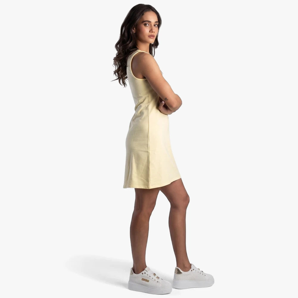 Pale yellow Sissy Boy boat neck mini dress with a bling logo, worn by a female model in a side profile view.