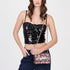 Sissy Boy Fancy Florals crossbody bag in multi-floral print, held by a model wearing a black sequin top and dark jeans.