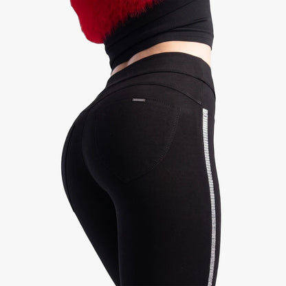 Close-up of black Sissy Boy Joey Sculpt Knit Jeggings with sparkly silver diamante tape side detail, worn by a model from