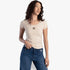 Woman modeling a Sissy Boy Future Lover short sleeve fashion top in stone beige, featuring the SB 86 logo, paired with
