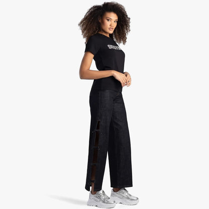Sissy Boy black regular fit tee with bling lettering, worn by a woman with dark jeans and silver sneakers. Full body.