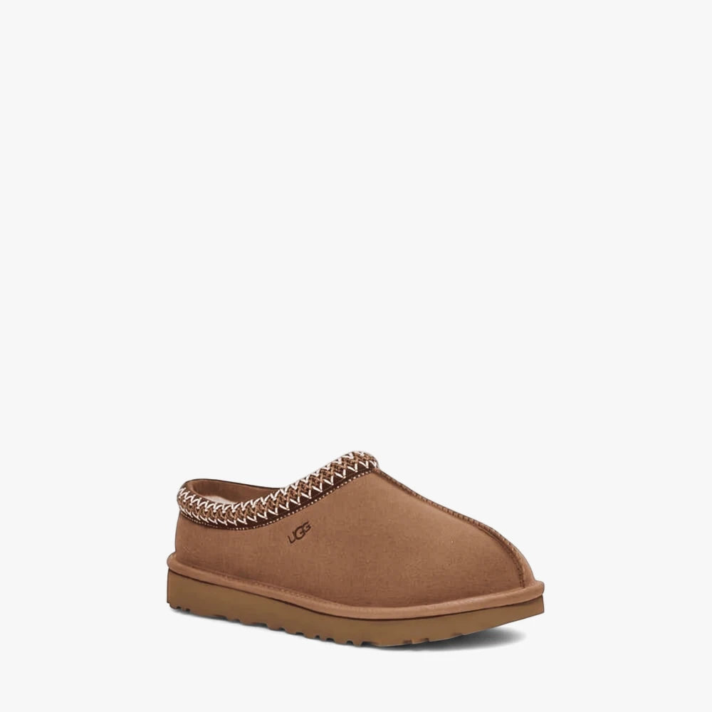 Ugg Womens Tasman slipper in chestnut brown suede, featuring a braided trim and a cozy sheepskin lining, shown from a side