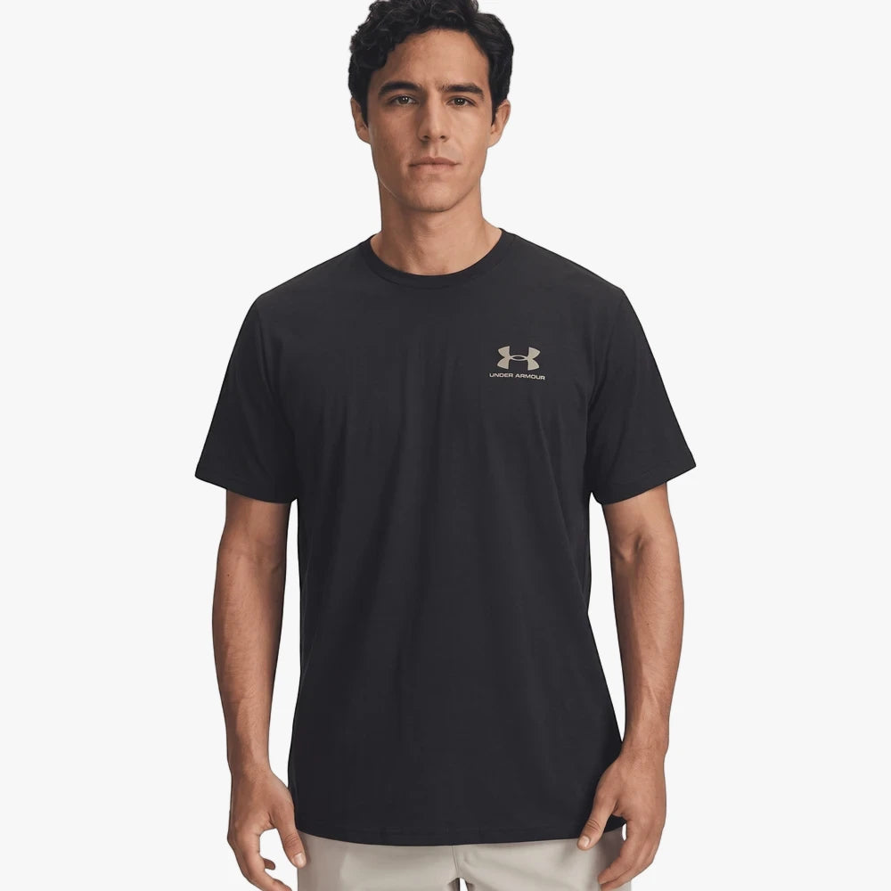 A man wearing a black Under Armour Mens Sportstyle Left Chest Short Sleeve Tee with a metallic grey logo.