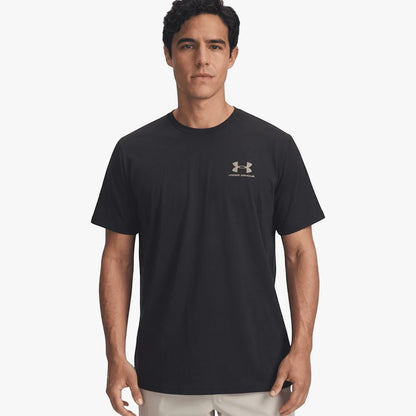 A man wearing a black Under Armour Mens Sportstyle Left Chest Short Sleeve Tee with a metallic grey logo.