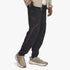 Under Armour Mens Unstoppable Cargo Pants in black, worn by a model, featuring zippered pockets and a comfortable fit,