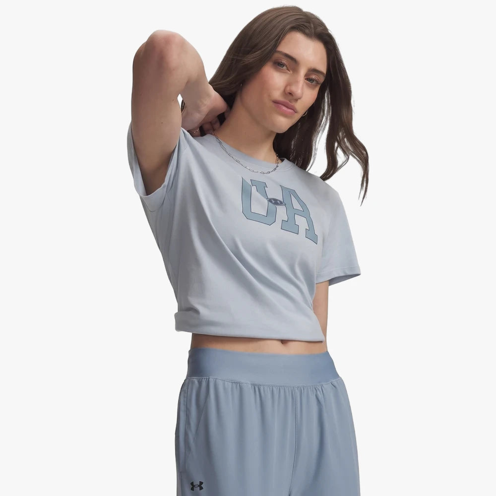 A woman models an Under Armour Womens Icon Fleece Graphic Tee in Blue Fog with matching blue athletic shorts.